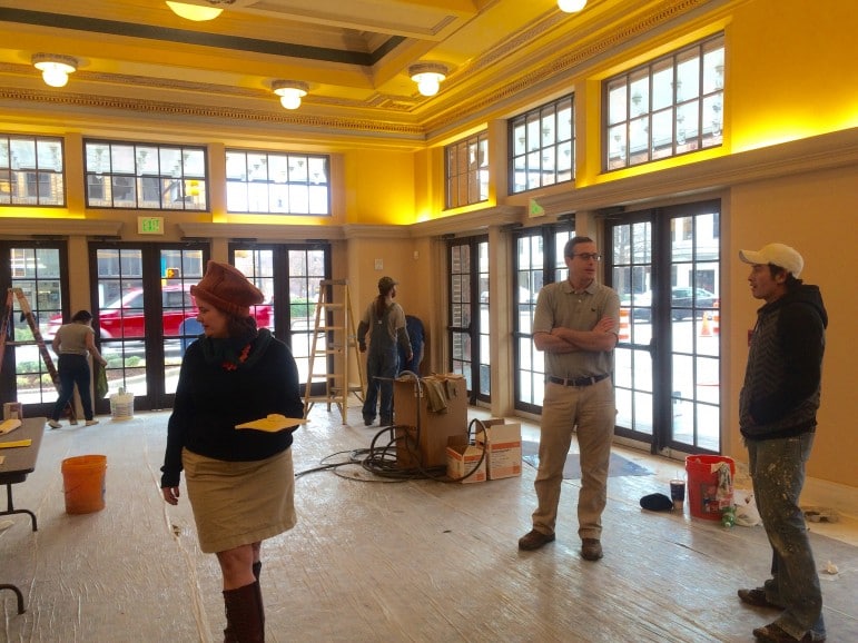 Glenny Brock walks through the lobby of the Lyric as workers apply some finishing touches. 