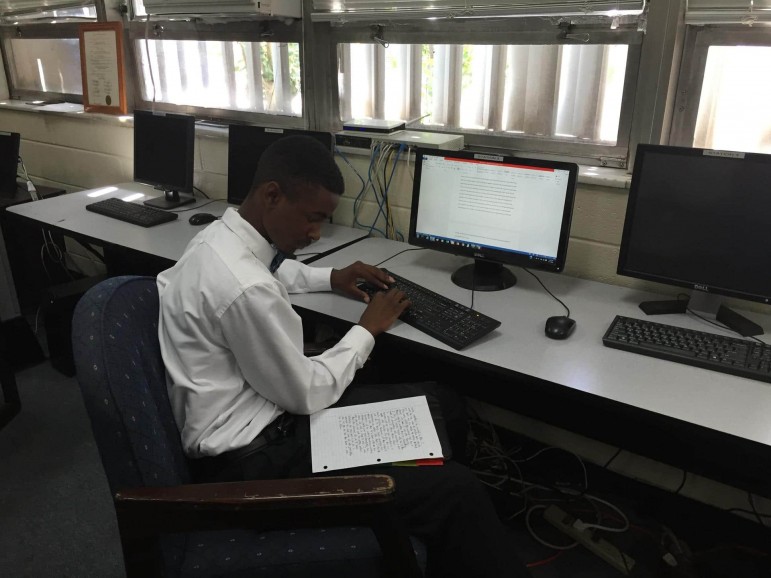 Cameron Taylor in the Holy Family Cristo Rey library working on an essay about his education and his future.