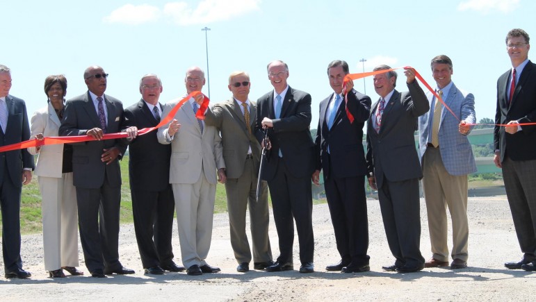 Governor Robert Bentley is surrounded by political and economic development leaders as he cuts the ribbon on the interchange between Interstate 22 and Interstate 65.