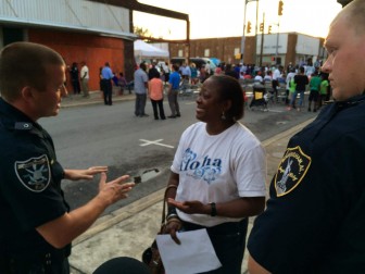 Corliss Cowart (center) talks with Officer Brandon Hill (left).