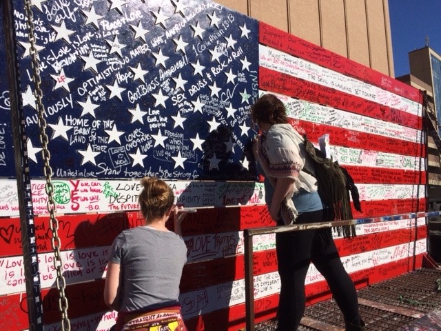 This is an art piece by Birmingham resident Ira Hill. People wrote their thoughts and feelings on this American flag and after the group marched around downtown, Hill invited those same people to paint over all the writing with pink paint. He says, "It's the power of people working together to make change." The idea was lost on some attendees at first and many thought Hill's artwork was a counter protest. Hill assured them it was not. 