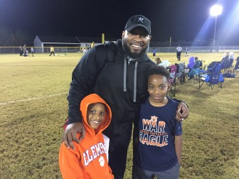 Coach Mike McClure Jr. with his sons Mason, 8 (left), and Xander, 10. Both sons play flag football.
