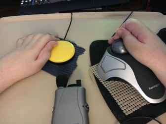 Joseph's yellow "buddy button" (a special clicker) and the trac-ball he uses to move his cursor.