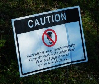 A caution sign warns the public at an area with frequent sewage overflows in Jefferson County.